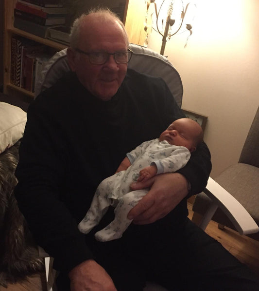 Image of a man on a rocking chair holding a baby
