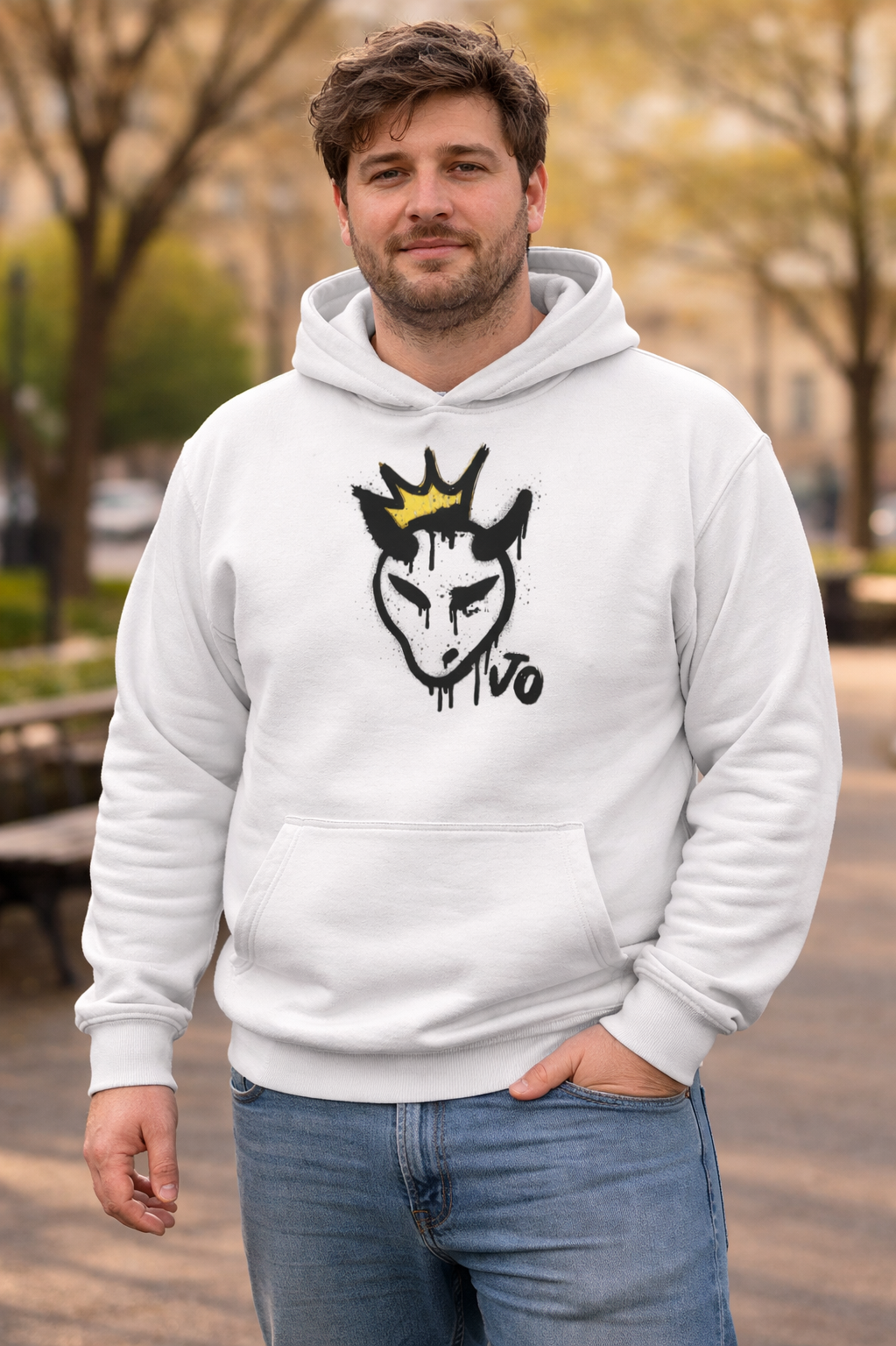 Man wearing a white hoodie with a graphic design outdoors