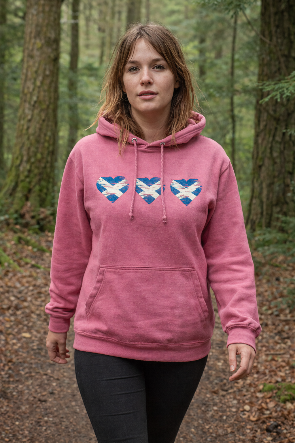 Person wearing a pink hoodie with blue and white designs in a forest setting