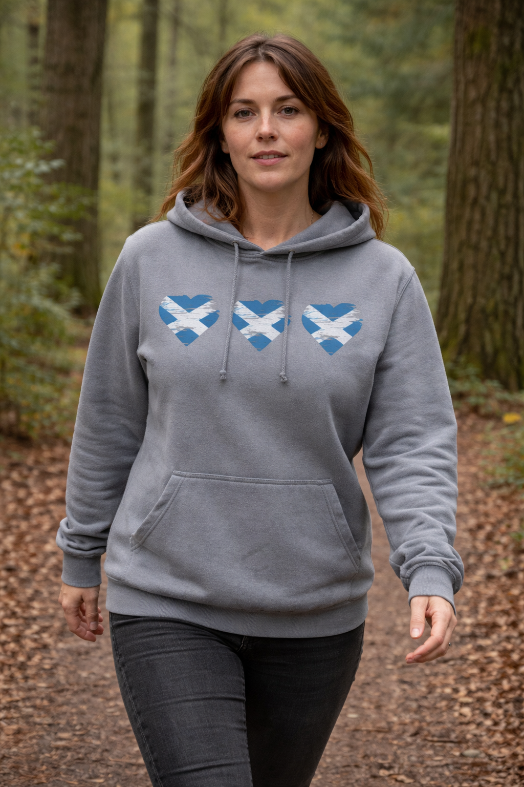 Woman wearing a gray hoodie with blue and white designs in a forest setting
