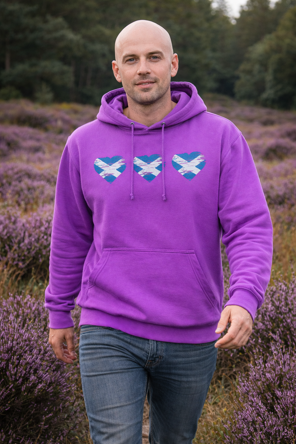 Man wearing a purple hoodie with blue designs standing in a lavender field.