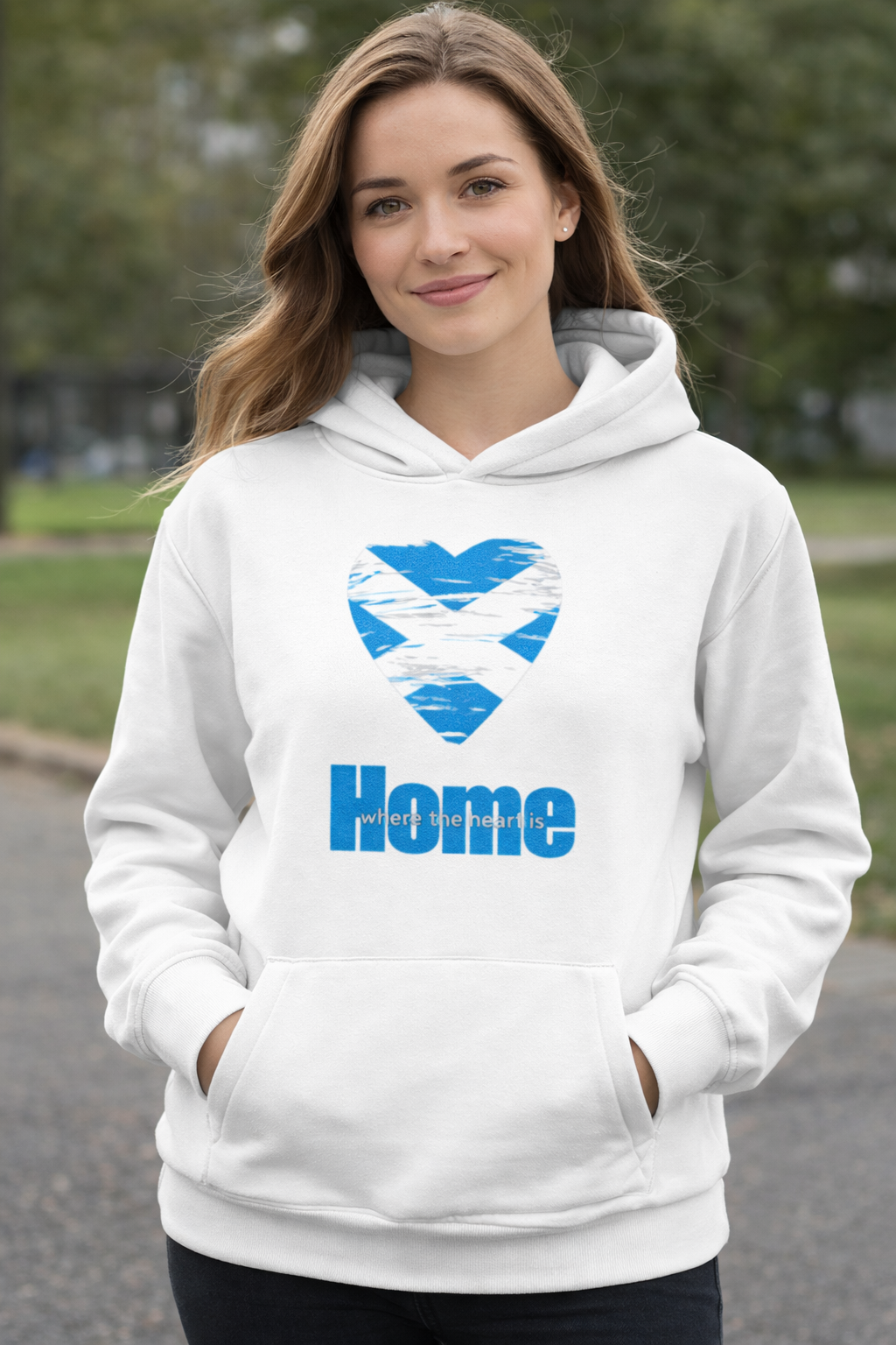 Woman outdoors wearing a arctic white hoodie with a saltire heart design and 'Home' text.