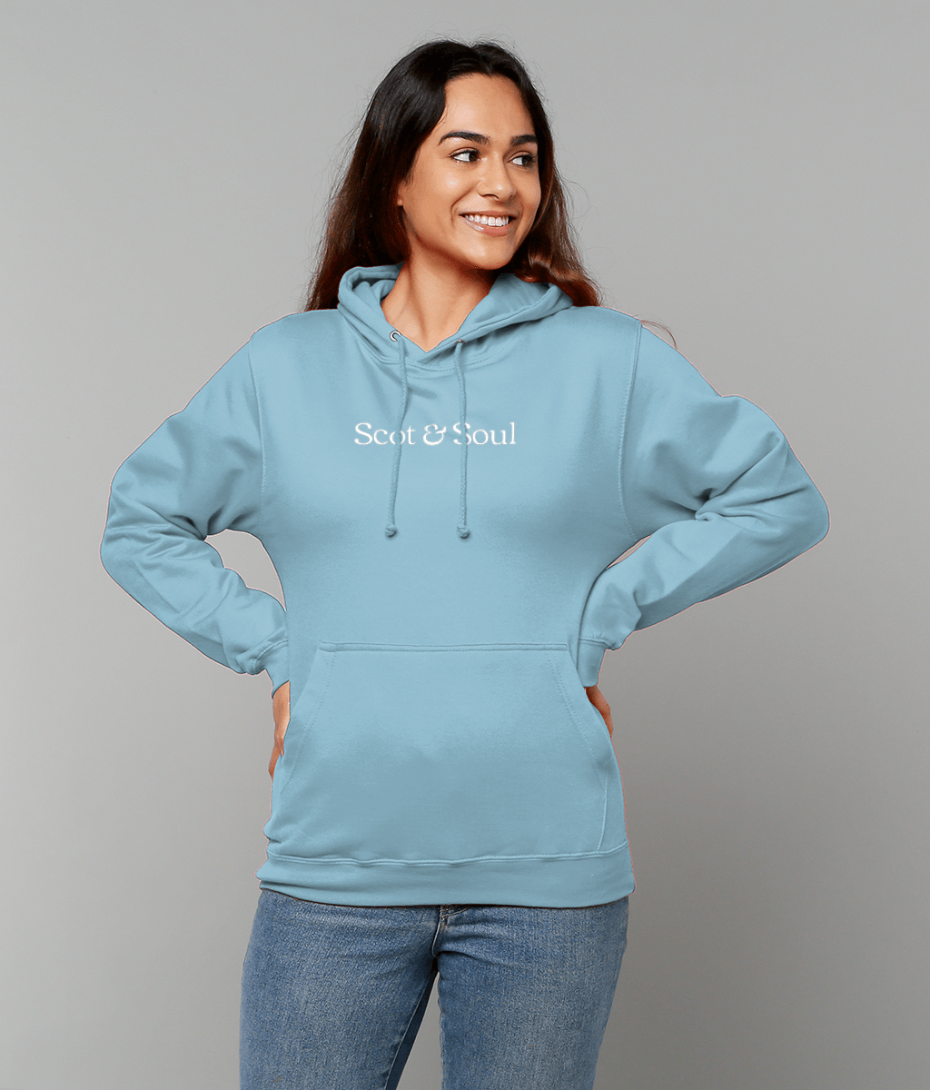 Woman wearing an ice blue hoodie with 'Scot & Soul' logo on a grey background